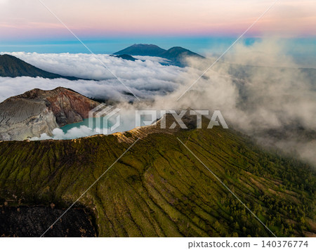 Aerial view of rock cliff at Kawah Ijen volcano with turquoise sulfur water lake at sunrise.Amazing nature landscape view at East Java, Indonesia. Natural landscape background Aerial view of rock cliff at Kawah Ijen volcano with turquoise sulfur water lake at sunrise.Amazing nature landscape view at East Java, Indonesia. Natural landscape background 140376774
