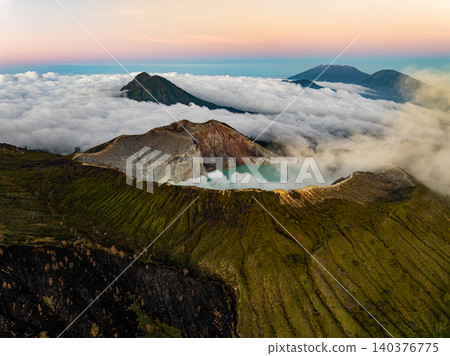 Aerial view of rock cliff at Kawah Ijen volcano with turquoise sulfur water lake at sunrise.Amazing nature landscape view at East Java, Indonesia. Natural landscape background Aerial view of rock cliff at Kawah Ijen volcano with turquoise sulfur water lake at sunrise.Amazing nature landscape view at East Java, Indonesia. Natural landscape background 140376775