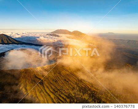 Aerial view of rock cliff at Kawah Ijen volcano with turquoise sulfur water lake at sunrise.Amazing nature landscape view at East Java, Indonesia. Natural landscape background Aerial view of rock cliff at Kawah Ijen volcano with turquoise sulfur water lake at sunrise.Amazing nature landscape view at East Java, Indonesia. Natural landscape background 140376778