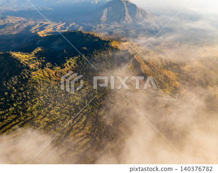 Aerial view of rock cliff at Kawah Ijen volcano with turquoise sulfur water lake at sunrise.Amazing nature landscape view at East Java, Indonesia. Natural landscape background 140376782