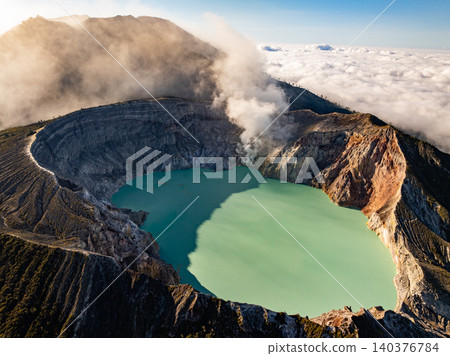 Aerial view of rock cliff at Kawah Ijen volcano with turquoise sulfur water lake at sunrise.Amazing nature landscape view at East Java, Indonesia. Natural landscape background 140376784