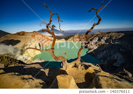 Aerial view of rock cliff at Kawah Ijen volcano with turquoise sulfur water lake at sunrise.Amazing nature landscape view at East Java, Indonesia. Natural landscape background 140376811