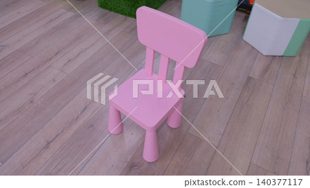 Colorful plastic kids chair. Pink children's chair in child room. Space for text. Stool for children in bright vivid playroom. Furniture for baby toddlers. Kindergarten preschool classroom concept Colorful plastic kids chair. Pink children's chair in child room. Space for text. Stool for children in bright vivid playroom. Furniture for baby toddlers. Kindergarten preschool classroom concept 140377117