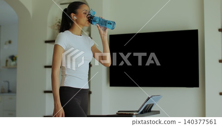 Workout, woman and walking on treadmill in home for cardio exercise, fitness challenge and burning calories. Workout, woman and walking on treadmill in home for cardio exercise, fitness challenge and burning calories. 140377561