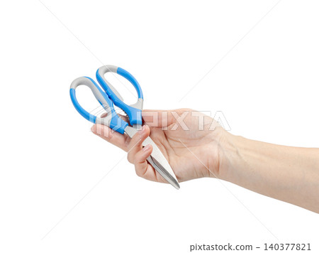 Kitchen scissors on the woman's palm with the white background. Kitchen scissors on the woman's palm with the white background. 140377821