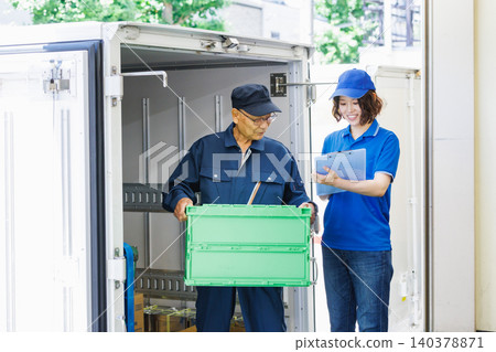 Senior workers and female drivers loading trucks 140378871