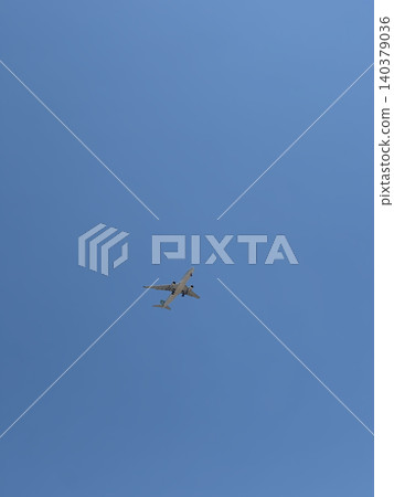 Commercial Airliner Flying Overhead in Clear Blue Sky With Lots of Open Space 140379036