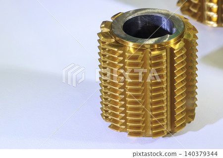 Close-up of a premium golden titanium nitride coated gear hob cutter tool on a white background. Close-up of a premium golden titanium nitride coated gear hob cutter tool on a white background. 140379344