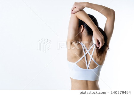 一位身材苗條的健身女性,從背後擺姿勢,伸展身體,進行肌肉訓練,減肥,節食。 一位身材苗條的健身女性,從背後擺姿勢,伸展身體,進行肌肉訓練,減肥,節食。 140379494