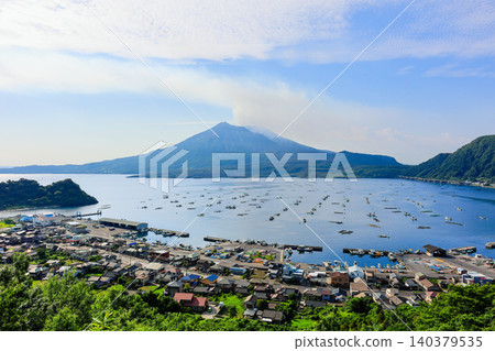 The townscape of Kaigata Fishing Port and the majestic Sakurajima as seen from Niko Observatory. 140379535