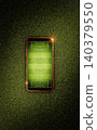 Mobile phone with soccer field screen on green grass lawn, top view	 140379550