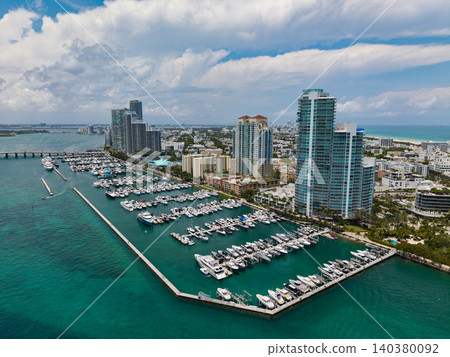 Luxury yacht docked at Miami marina. Aerial view of coastline in Miami. Sailboat cruising along the Miamis shore. Miami skyline above harbor. Famous Miami Beach marine from above. Marina with yachts. Luxury yacht docked at Miami marina. Aerial view of coastline in Miami. Sailboat cruising along the Miamis shore. Miami skyline above harbor. Famous Miami Beach marine from above. Marina with yachts. 140380092
