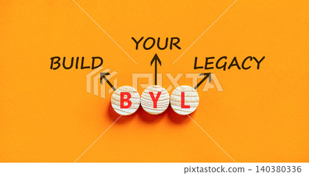 BYL build your legacy symbol. Concept words BYL build your legacy on beautiful wooden circles. Beautiful orange background. Business BYL build your legacy concept. Copy space BYL build your legacy symbol. Concept words BYL build your legacy on beautiful wooden circles. Beautiful orange background. Business BYL build your legacy concept. Copy space 140380336