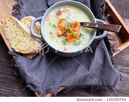 Creamy soup with mushrooms chanterelles and herbs 140380794