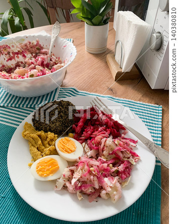 A nutritious breakfast featuring quinoa pancakes, fresh cabbage, radish, mung bean sprouts, boiled eggs, hummus, and roasted beets, perfect for a balanced start to your day A nutritious breakfast featuring quinoa pancakes, fresh cabbage, radish, mung bean sprouts, boiled eggs, hummus, and roasted beets, perfect for a balanced start to your day 140380810