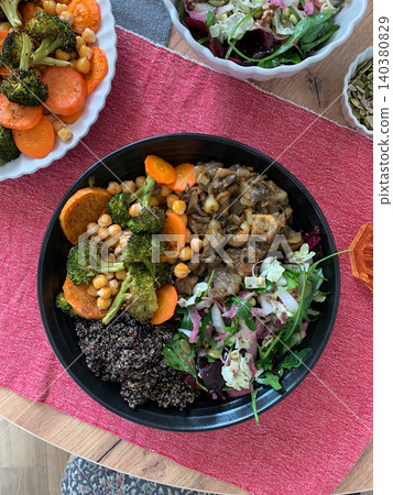 A nutritious breakfast bowl with black quinoa, avocado, roasted chicken, sweet potatoes, zucchini, and broccoli, paired with a fresh salad of cabbage, radish, chia, and sesame seeds A nutritious breakfast bowl with black quinoa, avocado, roasted chicken, sweet potatoes, zucchini, and broccoli, paired with a fresh salad of cabbage, radish, chia, and sesame seeds 140380829