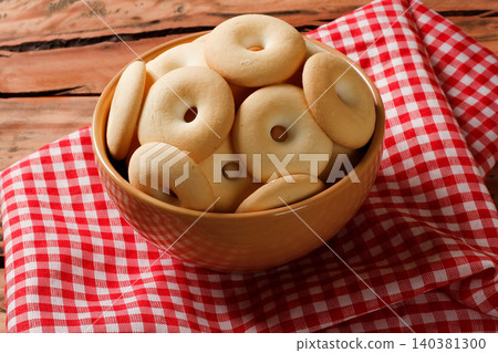 Brazilian Cassava Starch Cookies in ceramic Bowl on Red Checkered Cloth and Rustic Wooden Table Brazilian Cassava Starch Cookies in ceramic Bowl on Red Checkered Cloth and Rustic Wooden Table 140381300