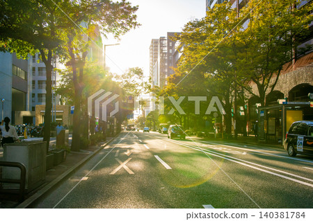 View of Meiji-dori Street from the traffic light in front of Chuo Ward Office, looking west; road, towards Akasaka; lens flare. View of Meiji-dori Street from the traffic light in front of Chuo Ward Office, looking west; road, towards Akasaka; lens flare. 140381784
