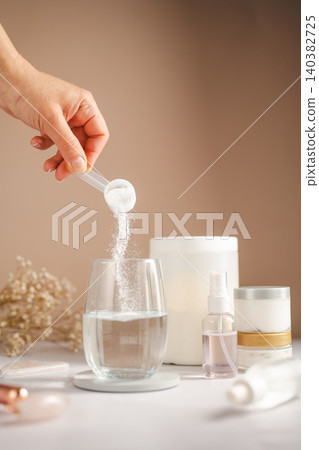 Collagen powder being added to pink beauty drink with skincare products and wellness concept Collagen powder being added to pink beauty drink with skincare products and wellness concept 140382725