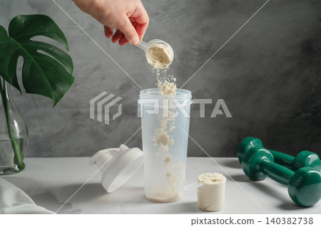 Whey protein powder being added to shaker for healthy lifestyle concept Whey protein powder being added to shaker for healthy lifestyle concept 140382738