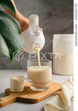 Pouring vanilla protein shake into glass, sports nutrition supplement and healthy lifestyle Pouring vanilla protein shake into glass, sports nutrition supplement and healthy lifestyle 140382776