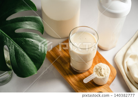 Protein shake with whey powder scoop on wooden board, healthy fitness nutrition Protein shake with whey powder scoop on wooden board, healthy fitness nutrition 140382777