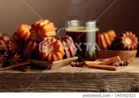 Cinnamon cakes and black coffee on an old wooden table. Cinnamon cakes and black coffee on an old wooden table. 140382825