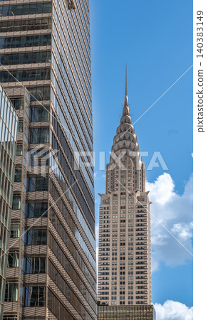 New york, usa august 22,2024. Chrysler building showcasing art deco architecture, framed by a modern glass skyscraper in manhattan, new york city skyline New york, usa august 22,2024. Chrysler building showcasing art deco architecture, framed by a modern glass skyscraper in manhattan, new york city skyline 140383149