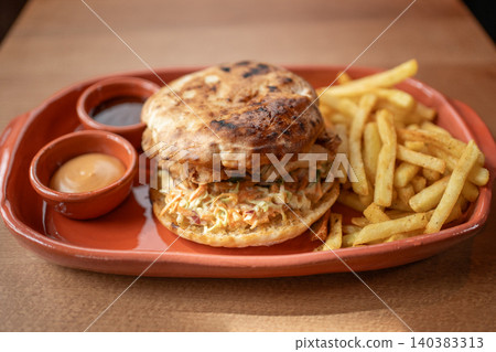 Scrumptious sandwich and crispy fries served on a rustic plate 140383313