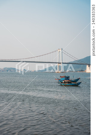 Fishing boats on Han river with Cau Thuan Phuoc bridge and city skyline at sunset in Da Nang, Traditional fisherman vessels on Golden Gate, calm water and mountains background, Danang Vietnam 4k Fishing boats on Han river with Cau Thuan Phuoc bridge and city skyline at sunset in Da Nang, Traditional fisherman vessels on Golden Gate, calm water and mountains background, Danang Vietnam 4k 140383363