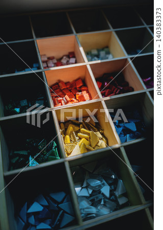 Colorful glass mosaic tiles in organized grid compartments for art and craft design, Assorted vibrant mosaic pieces collection for creative projects and decorative patterns Colorful glass mosaic tiles in organized grid compartments for art and craft design, Assorted vibrant mosaic pieces collection for creative projects and decorative patterns 140383373