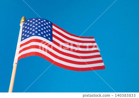 American flag waving proudly against blue sky American flag waving proudly against blue sky 140383833