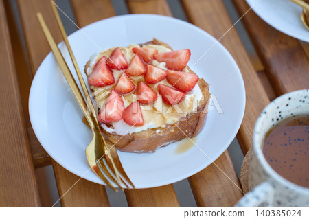 French toast with strawberries and honey, served with tea on a wooden table French toast with strawberries and honey, served with tea on a wooden table 140385024