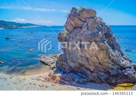 A giant rock standing on the beach A giant rock standing on the beach 140385113