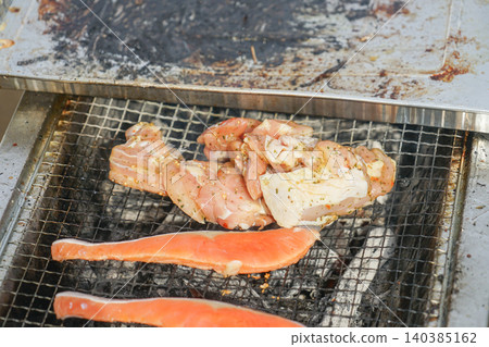 Salmon and meat grilled on a grill 140385162