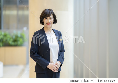 A portrait of a businesswoman in her 60s, smiling and looking directly at the camera. 140385356