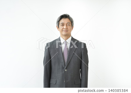 一位六十多歲的男子,穿著西裝,面帶微笑,直視鏡頭。 一位六十多歲的男子,穿著西裝,面帶微笑,直視鏡頭。 140385384