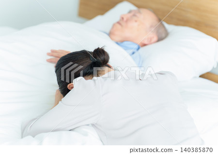 Woman suffering from caregiver burnout while nursing her sick father 140385870