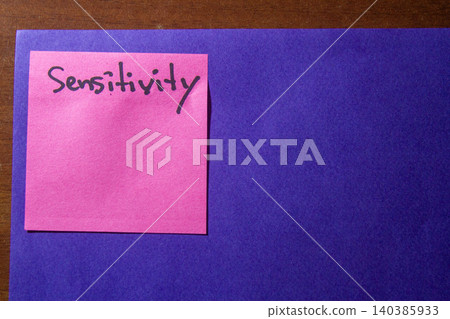 Pink sticky note with handwritten word Sensitivity on a blue background. Pink sticky note with handwritten word Sensitivity on a blue background. 140385933