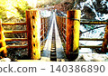 Beyond the suspension bridge, where light and shadow intertwine, lies a winter valley. 140386890