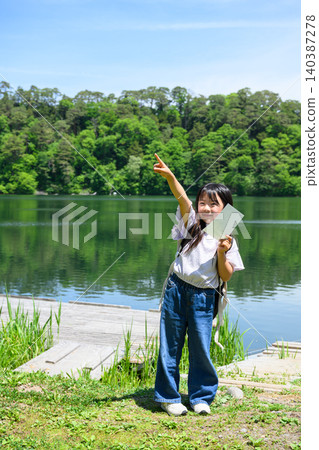 一群小學生在湖邊郊遊,她們興高采烈地舉起手,手裡拿著書籤,周圍是綠樹成蔭的湖面。 一群小學生在湖邊郊遊,她們興高采烈地舉起手,手裡拿著書籤,周圍是綠樹成蔭的湖面。 140387278