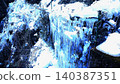 Along the snow-covered stream, countless icicles glow blue, creating a fantastical winter landscape. 140387351