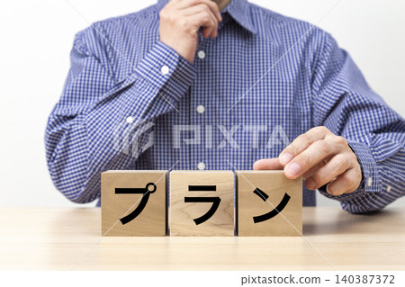 A block with the word "Plan" written on it and a man A block with the word "Plan" written on it and a man 140387372