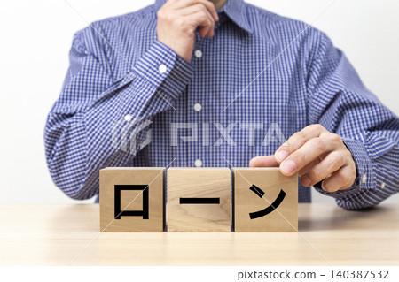 一塊寫著「貸款」字樣的磚塊和一個男人 一塊寫著「貸款」字樣的磚塊和一個男人 140387532