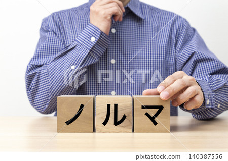 一塊寫著「配額」字樣的磚塊和一個男人 一塊寫著「配額」字樣的磚塊和一個男人 140387556