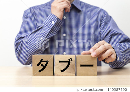 一塊寫著「禁忌」字樣的磚塊和一個男人 一塊寫著「禁忌」字樣的磚塊和一個男人 140387590