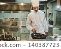 Culinary student practicing wok cooking with vegetables during professional kitchen training 140387723