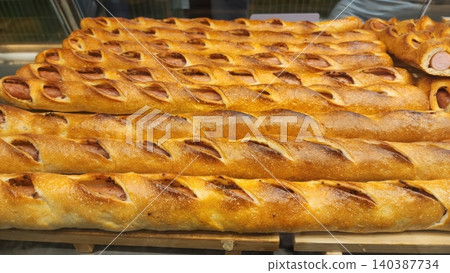 Freshly Baked Long Sausage Bread Rolls with Golden Crust Displayed in a Bakery Shelf Freshly Baked Long Sausage Bread Rolls with Golden Crust Displayed in a Bakery Shelf 140387734