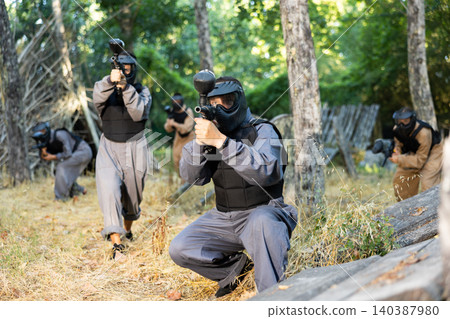 Teams facing on battlefield in outdoor paintball arena during match 140387980