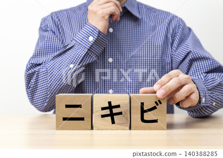 一塊寫著「痤瘡」字樣的磚塊和一個男人 一塊寫著「痤瘡」字樣的磚塊和一個男人 140388285